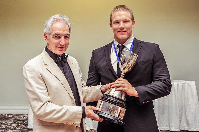 Vice-Chancellor Dr Max Price hands the Jamison Trophy to UCT's top athlete for 2014, water polo star Devon Card.