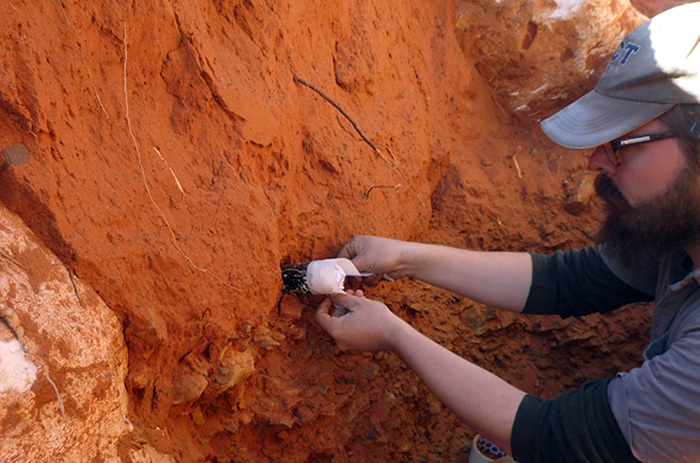 Mr Steven James Walker from the Department of Archaeology at UCT extracts a sample at the interface between the overlying red sands and the Earlier Stone Age archaeological deposits at the Kathu Townlands site. (Photo by Vasa Lukich)