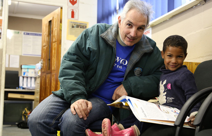 Pages of fun: Dr Max Price, UCT's Vice-Chancellor, shares the joy of reading with a youngster at SHAWCO's community centre in Manenberg on Mandela Day. Price joined more than 600 UCT students and staff at SHAWCO's centres around the Cape Flats in commemoration of the legacy of former president Nelson Rolihlahla Mandela.