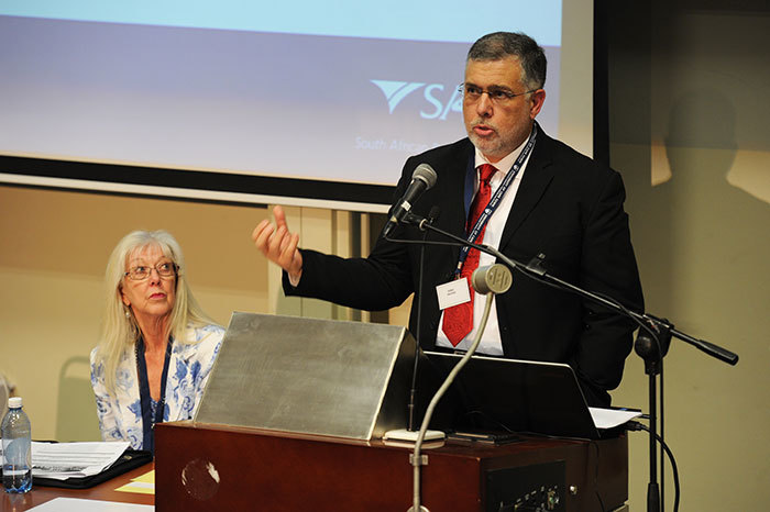 Dr Beric Croome from law firm Edward Nathan Sonnenbergs addresses attendees at the <i>Income Tax in South Africa: The first 100 years</i> conference, with Prof Jennifer Roeleveld, a conference organiser, looking on.