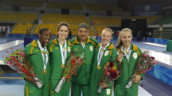 The women's epee fencing team (in green tracksuits) celebrate their gold medal at the African Games. Aphiwe Tuku, Giselle Vicatos (UCT Masters student), Randall Daniels (Manager), Tamryn Carfoot and Juliana Barrett. Photo supplied.
