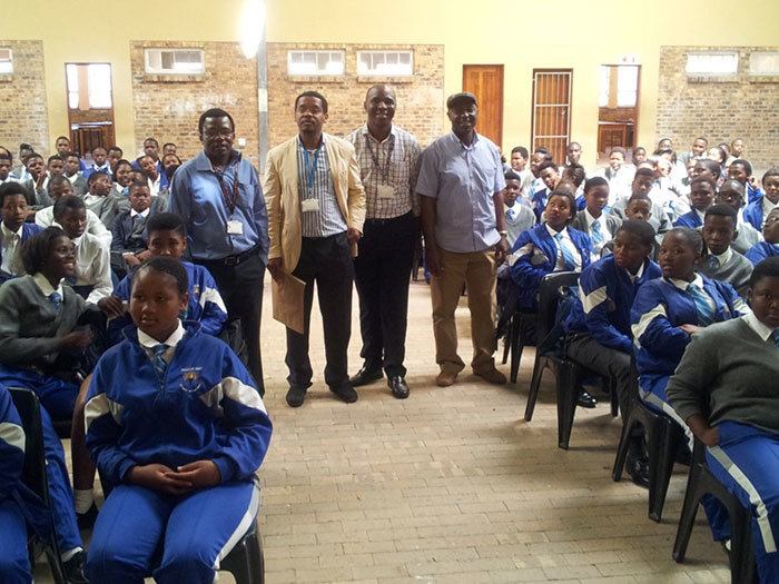 Standing between rows of seated Fezeka High learners (from left): Associate Professors Collet Dandara, Ambroise Wonkam, Ikechi Okpechi, and Dr Esau Ticha Muluh.