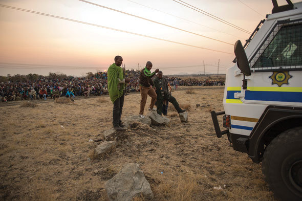 Lonmin employees gather at the base of a hill called Wonderkop at Marikana, outside Rustenburg in the North West Province of South Africa, 15 August 2012. The miners were calling for the minimum wage to be raised from R4 000 a month to R12 500.