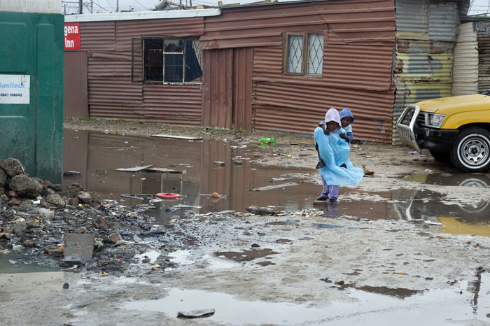 A child walks through a flooded informal settlement.