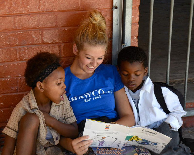 A love of reading: Two young pupils share the joy of reading with a SHAWCO volunteer, as part of the Little Moon project. On 16 May, the committee and SHAWCO Education will host a 'packaging' event with Stop Hunger Now, at which 360 meal-bags for the pupils will be prepared.