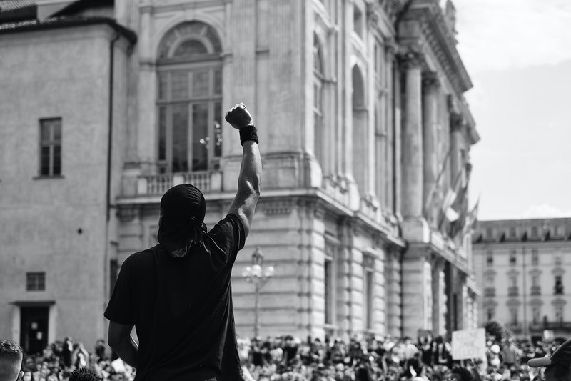 The COVID-19 pandemic provides us with the ideal opportunity to reimagine and rebuild. <strong>Photo</strong> <a href="https://www.pexels.com/photo/man-in-black-t-shirt-standing-infront-of-a-crowd-in-protest-4677606/" target="_blank">Marco Allasio/Pexels</a>.