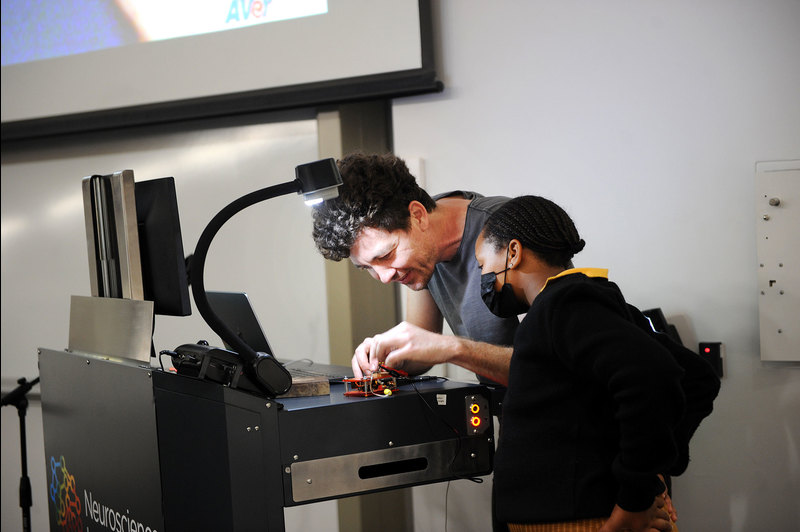 Dr Joseph Raimondo demonstrates the art of attaching electrodes to a segment of a cockroach. His volunteer is a Grade 7 learner from Bardale Primary School, one of two Mfuleni schools invited to the Neuroscience Institute’s International Brain Awareness Week programme.