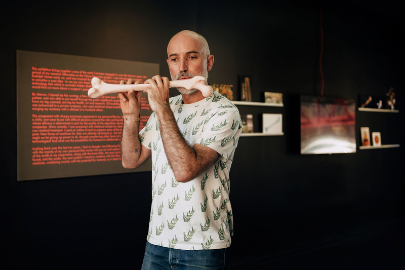 HUMA’s Dr Ralph Borland tests the bone flute, a 3D-printed replica of his thighbone. The flute was exhibited recently at Brutal Curation, Side Street Studios, in Woodstock, as part of his art-research project, Future Hospitals: 4IR and Ethics of Care in Africa. <b>Photo</b> Robyn Walker.