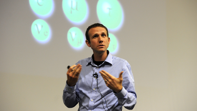 Basis of being: Dr Andrew Hamilton, pictured here at a 2012 public lecture about the possible sighting of the Higgs boson particle, was awarded a P-rating for his continuing insights into the understanding the Universe at its most fundamental level.