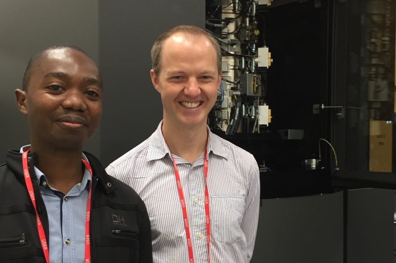 UCT researchers Dr Andani Mulelu and Dr Jeremy Woodward stand next to the super-microscope they used to make their biochemistry breakthrough at the Electron Bioimaging Centre at Diamond Light Source in the United Kingdom. <b>Photo</b>&nbsp;Adriana Klyszejko. 