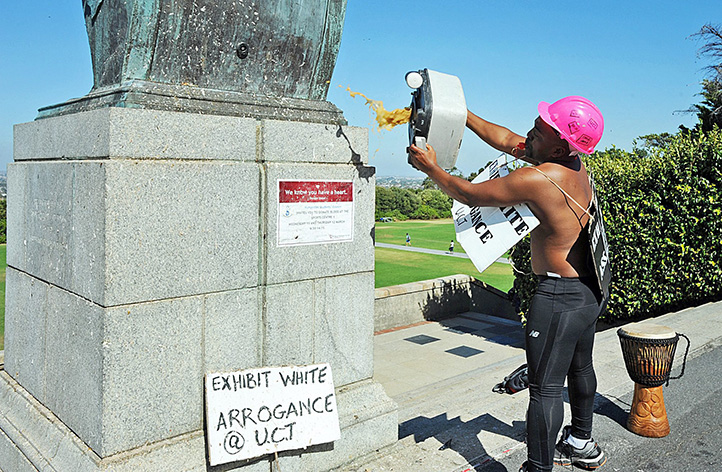 On 9 March 2015, fourth-year political science student Chumani Maxwele throws what appears to be human excrement at the statue of Cecil John Rhodes on the campus rugby field, saying that many black students are offended by the colonial atmosphere at UCT. Photo by David Ritchie, <em>Cape Argus</em>.