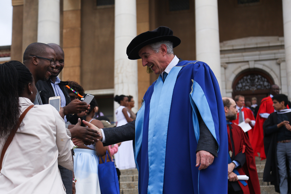 Vice-Chancellor Dr Max Price shakes hands with a student after their graduation ceremony.