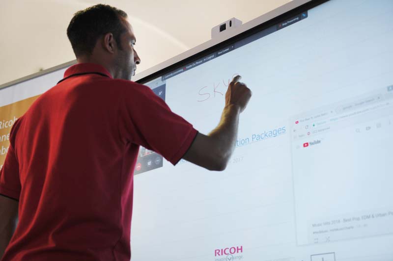 A Ricoh exhibitor demonstrates some of the capabilities of the Ricoh interactive whiteboards.