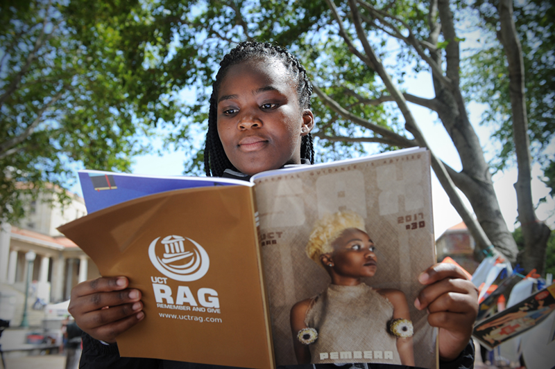 SAX Appeal had an art display of all their historic cover art displayed at the plaza in front of the Sarah Baartman Hall on upper campus. Lisakhanya Hulushe is seen here reading.