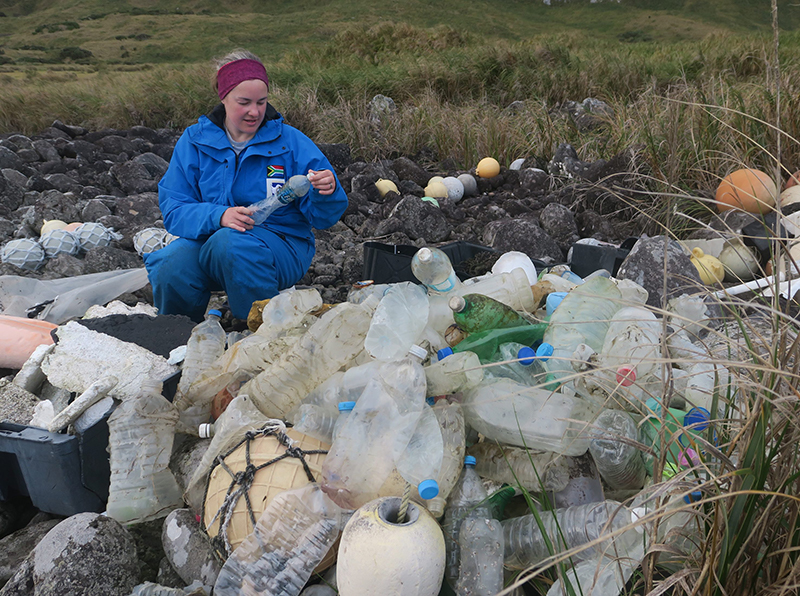 Co-author of the study Dr Maëlle Connan scores bottles washed ashore on the west coast of Inaccessible Island.