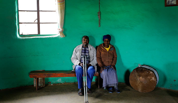 Grandfather and subsistence farmer Selby Hambisa, 79, sits with his wife Nolayani Hambisa, 62, in their family communal mud hut in the hills near Coffee Bay, South Africa.