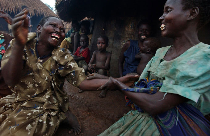 Two Northern Ugandan women – whose lips had been cut off by rebels during one of Africa's longest-running armed conflicts – sharing a lighter moment. In his thesis, Samson Barrigye argues that peacemaking and conflict resolution efforts should have involved more ordinary citizens and more bottom-up processes. <a href="http://commons.wikimedia.org/wiki/File:Gulu_women_-_cut_lips.jpg" target="_blank">Photo courtesy of USAID</a>, accessed via Wikimedia Commons.