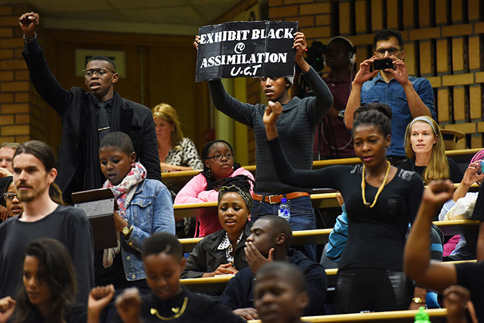 UCT SRC president <a href="/dailynews/?id=9044" target="_blank">Ramabina Mahapa addresses the audience</a> before leading a student walkout at the "Heritage, signage and symbolism" seminar on 16 March. The seminar was to have been the first of series of discussions about transformation-related issues. Seated are (l-r) Assoc Prof Nick Shepard (African Studies and Archaeology), UCT Council member Alderman Owen Kinahan and spatial historian Sally Titlestad.