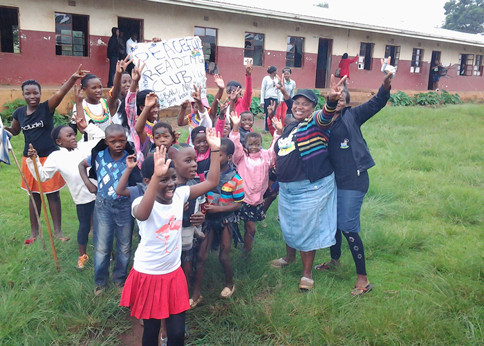 hulisa Mayekiso, Nal'ibali cluster mentor, assists children with their first steps towards reading and writing at one of the Nal'ibali reading clubs she oversees in Masiphumelele township. Mayekiso's club form part of a network of over 300 Nal'ibali reading clubs across the country.