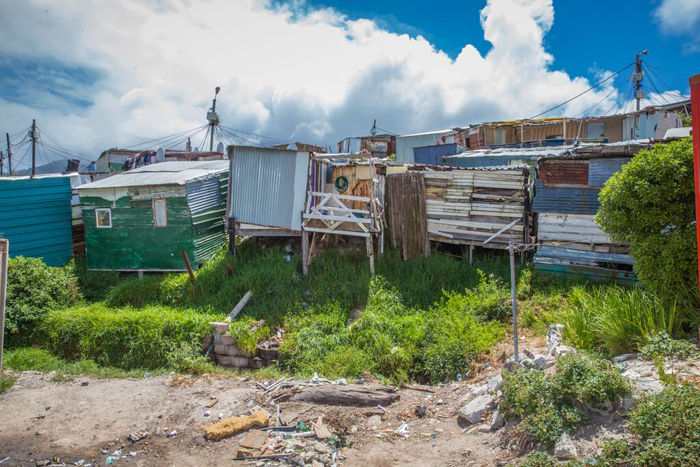 Imazamo Yethu is an informal settlement located directly next to the wealthy Cape Town suburb of Hout Bay. Image of Imazamo Yethu <a href="http://creativecommons.org/licenses/by/2.0" target="_blank">CC BY 2.0</a>, via <a href="https://commons.wikimedia.org/wiki/File%3AMapa_de_la_inequidad-gini.svg" target="_blank">Wikimedia Commons</a>