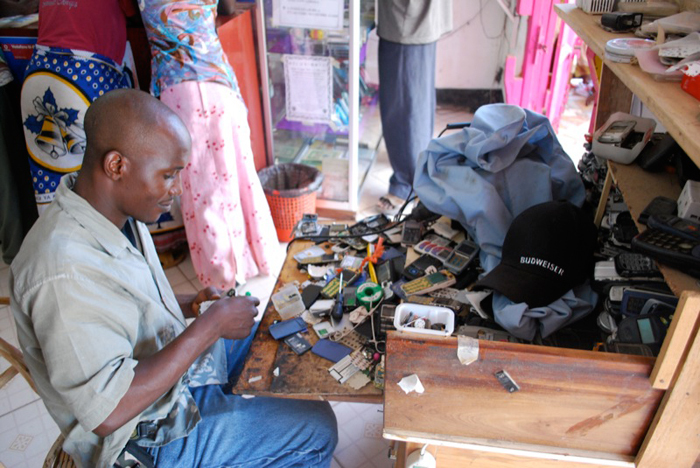 African case study: Dr Linda Ronnie's award-winning M-Pesa case study documented how Vodacom embraced mobile financial services by using cellphone technology. This image shows an M-Pesa agent fixing cellphones in Bunda, Tanzania.