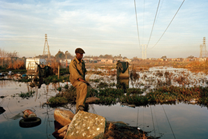 Jeffrey Ramiruti looks out over a stretch of water that has flooded a large part of the Tudor Shaft informal settlement which is built on top of mine tailings.