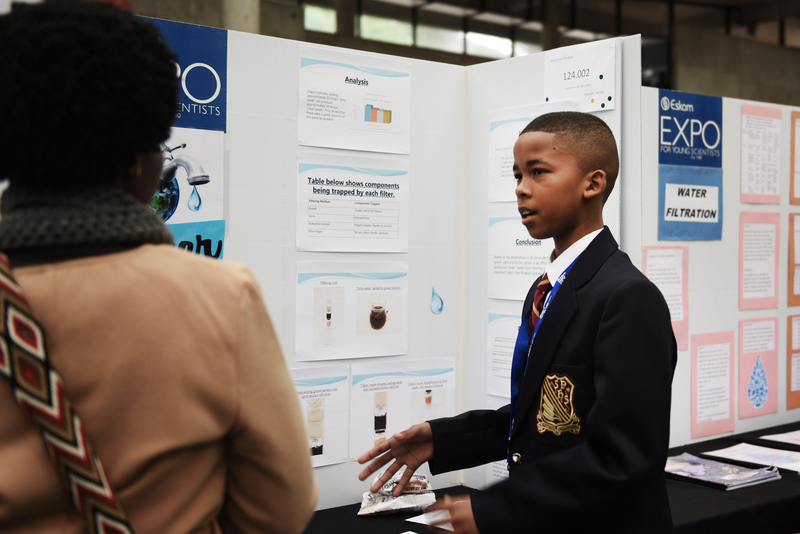 Alistair Filander of South Peninsula High School describes his water filtration system to one of the judges.