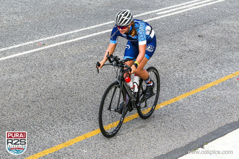 Megan Anley on her bicycle during the difficult cycling leg, battling a relentless headwind.