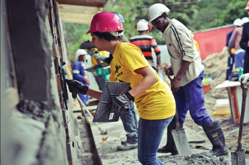 Builder Bob: Postgraduate student Salma Kagee slaps plaster on bricks. Kagee was one of the Faculty of Commerce's volunteers helping to extend the Philippi Children's Centre. It's linked to the R150 million Starting Chance Campaign, initiated by the Southern Africa Sustainable Development Initiative.