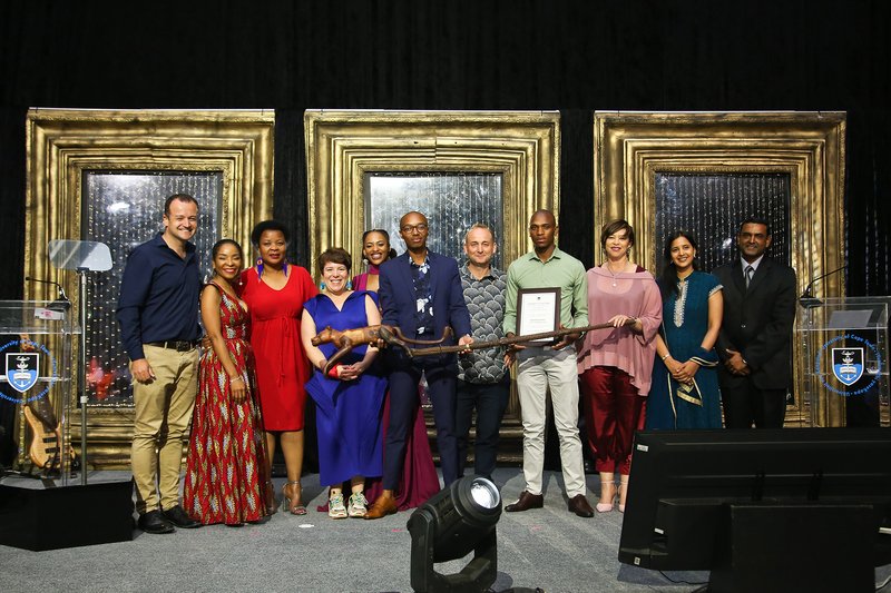 VC Prof Mamokgethi Phakeng (second from left) and DVC Prof Loretta Feris (third from right) congratulate the marketing section in the School of Management Studies for winning the Vice-Chancellor’s Award for Transformation, presented at the UCT Annual Awards ceremony. (The leopard staff was created by Thami Kitty.) <b>Photo</b> Je’nine May.