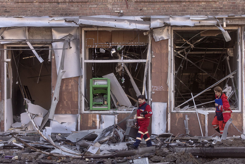 Emergency services personnel walk amid debris from a damaged residential apartment block caused after a Russian rocket was shot down by Ukrainian air defences on 14 March  2022 in Kyiv, Ukraine.
