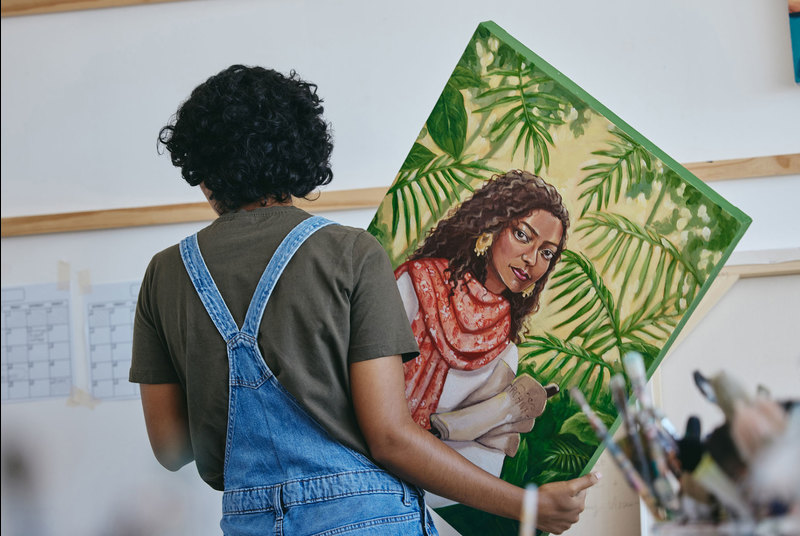 The popular &ldquo;Res4Res: Our Stories&rdquo; art festival for residence students has been revamped this year and will be presented in an exhibition format. <b>Photo </b><a href="https://www.istockphoto.com/photo/painting-woman-artist-and-hanging-canvas-wall-for-exhibition-expo-sale-and-gallery-gm1445405777-483824665?phrase=art+exhibition" target="_blank">iStock</a>.