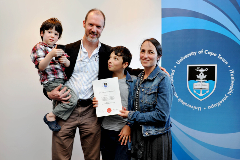 Winning smiles: The recipient of the 2013 Alan Pifer Award, Assoc Prof Crick Lund, is congratulated by his wife, Justine Evans, and sons Jacob (12) and Sam (4).