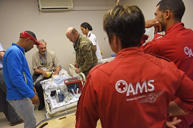 UCT's Prof Andrew Argent (seated) plays the role of a doctor in situ as paramedics arrive to practise the collection of a seriously ill "baby" for an air transfer, during a <a href="http://www.uct.ac.za/news/multimedia/photo_albums/weeklygallery/#EMS" target="_blank">simulation exercise</a>.