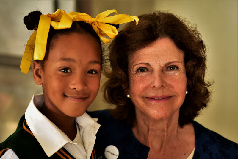 Queen Silvia of Sweden poses with Rayneshia van Rooyen from Touwsranten Primary School.