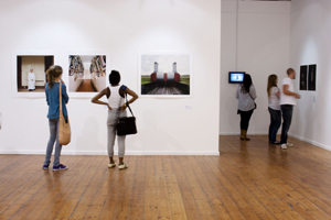 Visitors ponder the photographs in reGeneration2