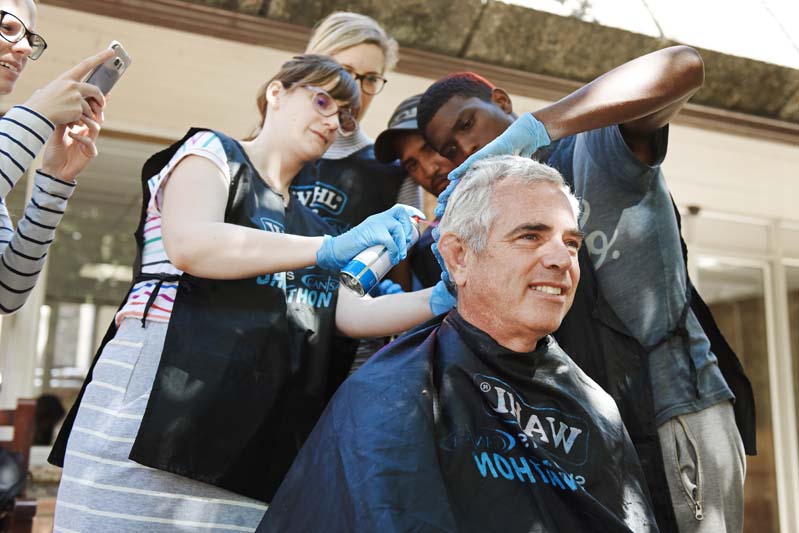 Professor Malcolm Collins, head of the Department of Human Biology, has a Superman logo sprayed onto his hair by the entire team to show his support.