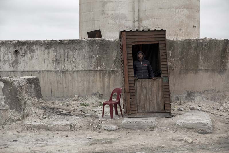 In/between is filled with images of walls and boundaries: barriers to keep people out, and to separate them. “He’s there to make sure nobody occupies this space in the industrial area there. That is his primary job, and this photograph speaks to the constant tension and need of living space.”