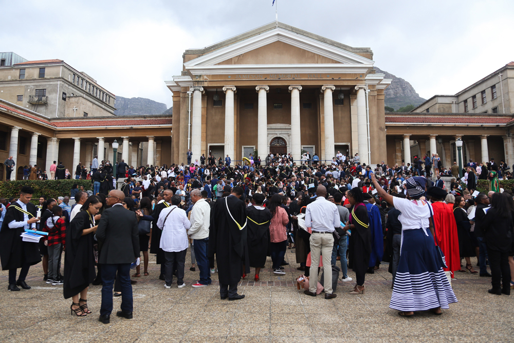 New graduates and their parents celebrate on the plaza.