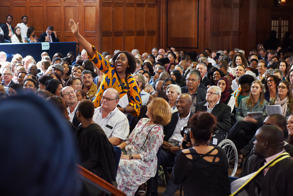 A mother celebrates as her child takes to the stage during a Humanities graduation ceremony.