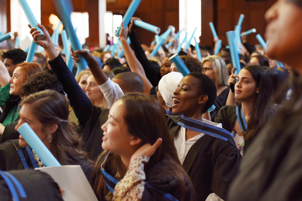 Graduates turn to face their families and loved ones to thank them for their support while earning their degrees.