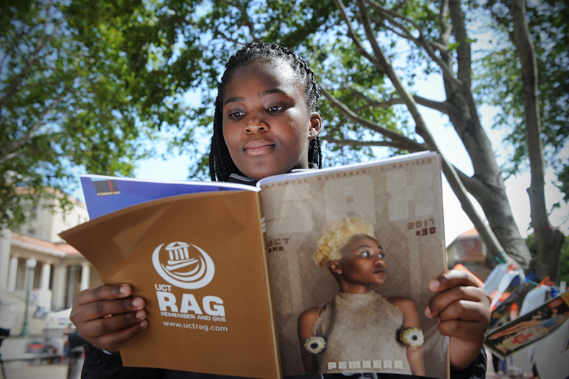 SAX Appeal had an art display of all their historic cover art displayed at the plaza in front of the Sarah Baartman Hall on upper campus. Lisakhanya Hulushe is seen here reading.