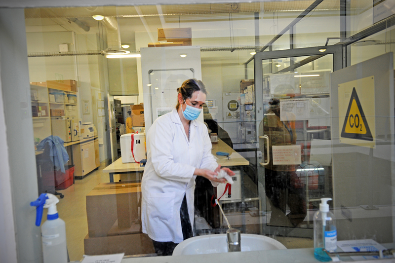 Melissa Jayne Walcott Blumenthal, postdoctoral research fellow in the Department of Integrative Biomedical Sciences (IBMS) affiliated with the Institute of Infectious Disease and Molecular Medicine (IDM) in the Faculty of Health Sciences. Seen here wearing PPE inside a testing lab. 